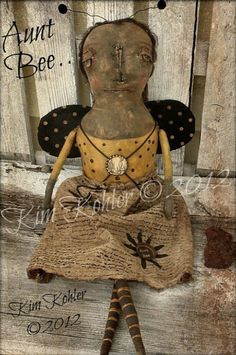 an old fashioned doll is sitting on a wooden chair with the words hunt bee written above it