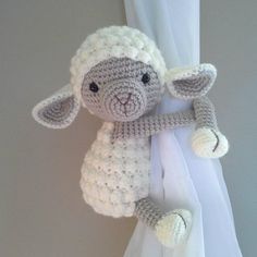 a crocheted stuffed animal hanging from a curtain