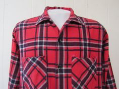 "Vintage 1960s shirt. Made of red, black and white plaid cotton flannel. Has two chest pockets, button front and button cuffs. Made by Sportswear. Size large. Actual measurements are: 43\" around the chest 43\" at the waist 18\" shoulder seam to shoulder seam 23.5\" shoulder seam to end of cuff 28.5\" overall length In very good condition with a 1/8\" rip at pocket corner - see picture." Retro Collared Flannel Shirt With Pockets, Vintage Plaid Flannel Shirt With Pockets, Vintage Collared Flannel Shirt, Vintage Red Flannel Shirt, Retro Collared Flannel Shirt For Winter, Retro Plaid Button-up Flannel Shirt, Vintage Plaid Collared Shirt, Retro Plaid Flannel Shirt With Buttons, Vintage Plaid Flannel Shirt