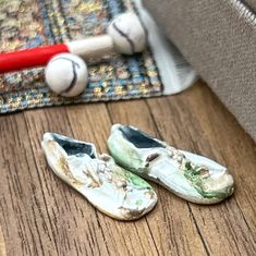 a pair of shoes sitting on top of a wooden floor next to a baseball bat