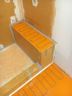 boxes are stacked on top of each other in an unfinished room with orange flooring