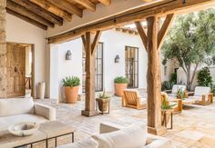 an outdoor living area with white furniture and potted plants