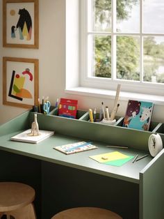 an office desk with various stationery items on it and a window in the background