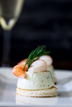 shrimp and scallop on crackers with a glass of wine in the background