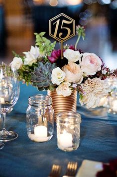 an image of a table setting with flowers and candles on it for the centerpiece