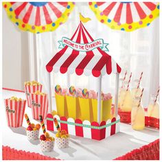 an image of a carnival party setting with popcorn and drinks on the table in front of it