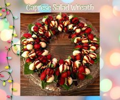 a cake decorated with strawberries on top of a wooden table next to a string of lights