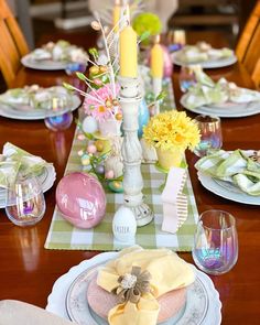 a table set for easter dinner with flowers and candles