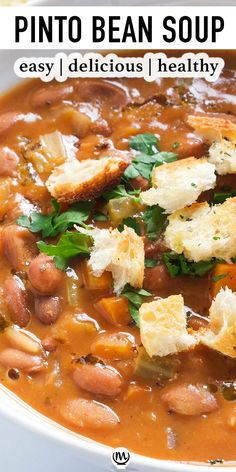 a white bowl filled with bean soup and croutons