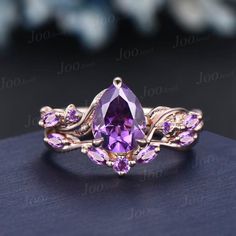 an amethorate ring with purple stones and leaves on the band, set in gold