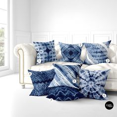 a white couch with blue and white pillows on it