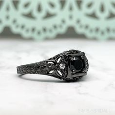 M A T E R I A L S ~ Solid Sterling Silver ~ Black Rhodium S T O N E S Cruelty Free ~ Simulated Black Diamond ~ Center Stone : 0.45ct ~Side White Diamonds: 0.12ct D I M E N S I O N S ~ Band: 3.00mm ~ Setting: 5.75mm Height 9.00mm Width R I N G C A R E ~ Simple instructions to care for the ring is not expose your jewelry to chemicals like bleach, chlorine, hairspray, to avoid chemical reactions or breakdown of materials. (Just as you would with any jewelry) ~ Try not wear your jewelry in the showe Classic Black Rings For Anniversary, Classic Black Diamond Ring As A Gift, Classic Black Diamond Ring Gift, Classic Black Diamond Ring For Gift, Gothic Black Promise Rings, Black Spinel Rings For Anniversary, Black Spinel Rings For Promise, Anniversary Black Spinel Rings, Gothic Black Promise Jewelry