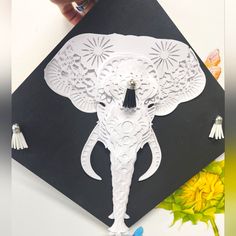 an elephant made out of paper sitting on top of a black and white piece of paper