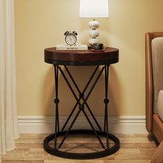 a small table with a clock on it next to a chair and lamp in a room