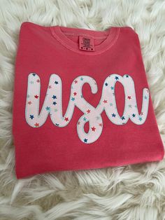 a t - shirt with the word usa on it is laying on a fur surface