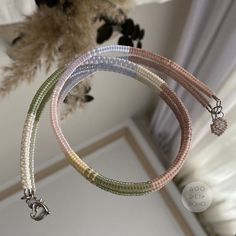 three bracelets with charms hanging from the ceiling