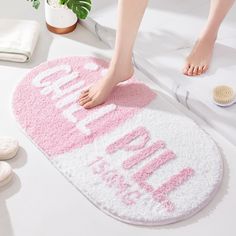 a person standing on top of a bath mat with the word hello kitty written on it