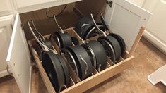 pots and pans are stored in a drawer on the kitchen floor, ready to be cleaned