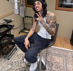 a man with dreadlocks sitting on a chair in front of a recording studio