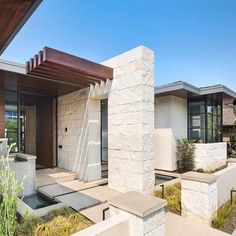 a modern house with white stone and wood accents