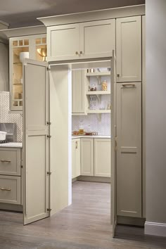 a kitchen with white cabinets and an open door