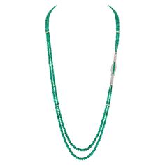 This long and sleek necklace is as striking as it is comfortable. The designer happened across a vintage treasure made with 2.3 Carats of Precision Set Emeralds and surrounded with 2.66 Carats of Round Brilliant and Baguette Diamonds. The lines of the piece inspired this long two-strand necklace pairing 215 Carats of smooth Rondelle Emeralds ranging from 2.5 - 8 mm held together perfectly with an additional 4 spacer bars crafted in the same sleek baguette design as the focal point adding an addi