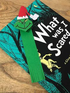 a close up of a book on a wooden surface with a green ribbon around it