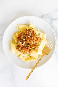 a white plate topped with pasta covered in sauce and parmesan sprinkles