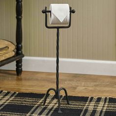 a toilet paper holder on a wooden floor next to a rug and chair in a room