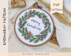 a cross stitch christmas wreath with the words merry christmas on it and some other items