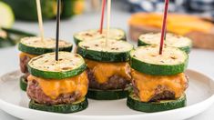 cucumber sandwiches with cheese and pickles on a white plate, ready to be eaten