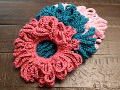 three crocheted scrunffles sitting on top of a wooden table