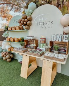 a table topped with lots of desserts next to a sign