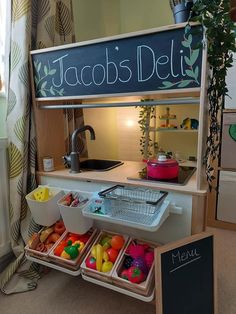 a display case filled with lots of different types of fruit and vegetables next to a sign that says taco's deli