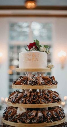 a three tiered wedding cake with frosting and pretzels on the bottom