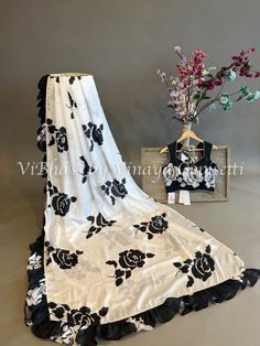 Unleash your inner goddess in this fearless Floral Black And White Satin Crepe Ruffle Saree And Blouse. Designed for the courageous, it features chic, ruffled detailing that elevates any night out. Soar through every occasion with confidence and style. The Saree is provided with a matching saree skirt / petticoat. Black Saree With Floral Blouse, Fancy Designer Sarees, Black Floral Embroidered Saree For Festivals, Floral Ruffle Saree, Ruffle Saree Blouse, Black Saree With Printed Motifs, Luxury Black Saree With Printed Border, Black Flower Print Saree, Saree Satin