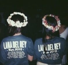 two people wearing t - shirts with flowers in their hair