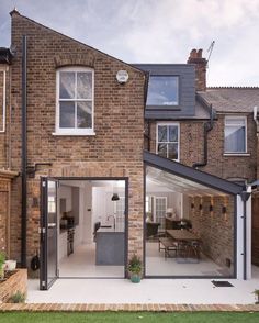 a brick house with an open patio and dining area