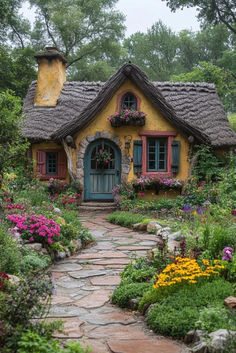 a small yellow cottage with flowers and plants around the front door is surrounded by greenery