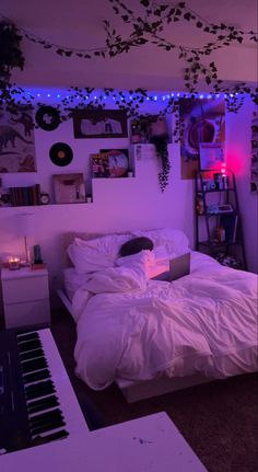 a bedroom with a laptop on the bed in front of a purple light that is turned on