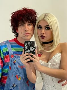 two people dressed up as zombies and one is holding a cell phone with her mouth open