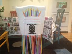 a chair that has been decorated with different colored ribbons on the back of it,