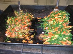 carrots and other vegetables being cooked in a grill