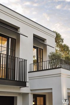 two story white building with black balconies