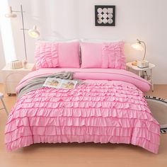 a bed with pink ruffled sheets and pillows