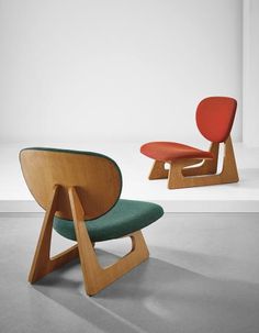 two chairs in different colors and shapes, one with a foot rest on the other