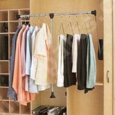 an open closet with clothes hanging on the rails