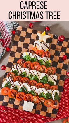 a christmas tree made out of tomatoes and mozzarella cheese on a cutting board