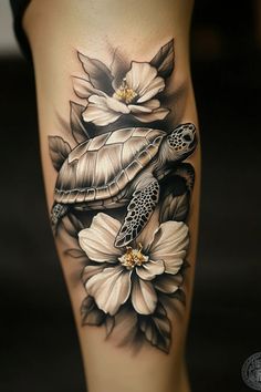 a woman's thigh with a turtle and flowers on it