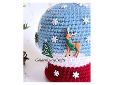 a crocheted christmas ornament on top of a knitted hat with snowflakes